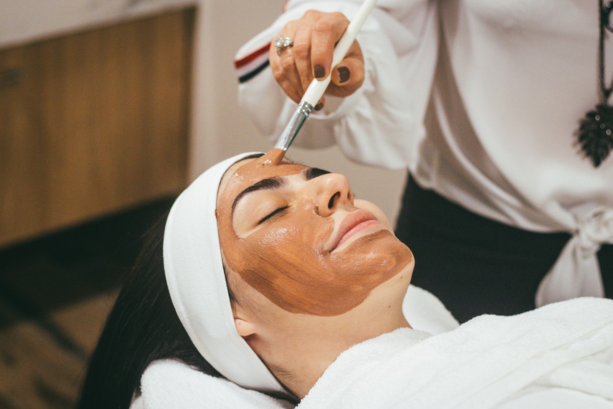 A serene multicultural client receiving a luminous facial treatment